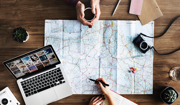 a person using a laptop and looking at a map